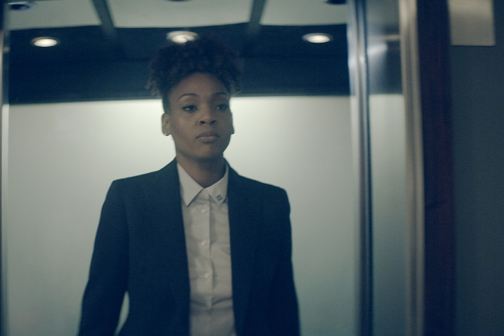 Woman in a suit exits an elevator