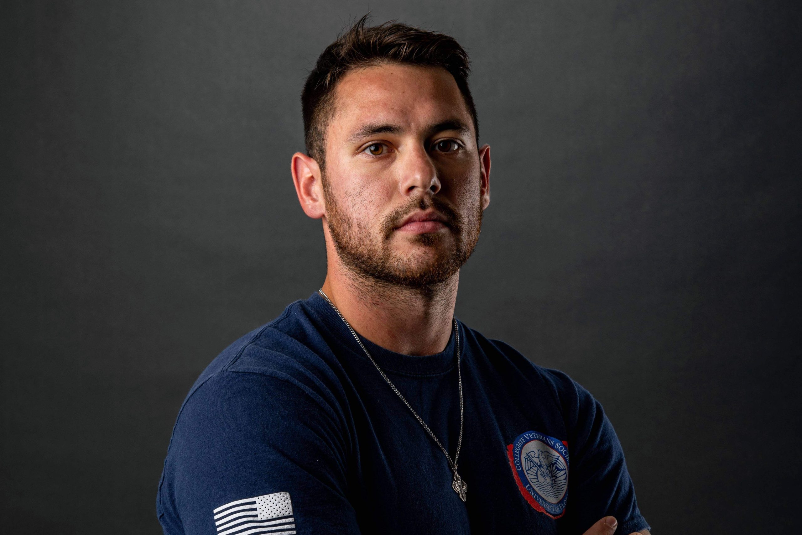 Portrait of man in blue shirt standing on gray background